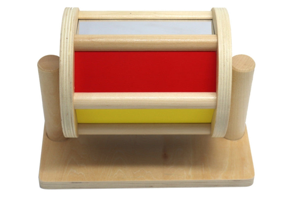 Colourful wooden spinning drum. A reflective side, a red side, and a yellow side are visible.