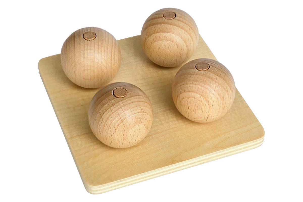 Four wooden balls, each on a vertical dowel flush with the top of the ball.