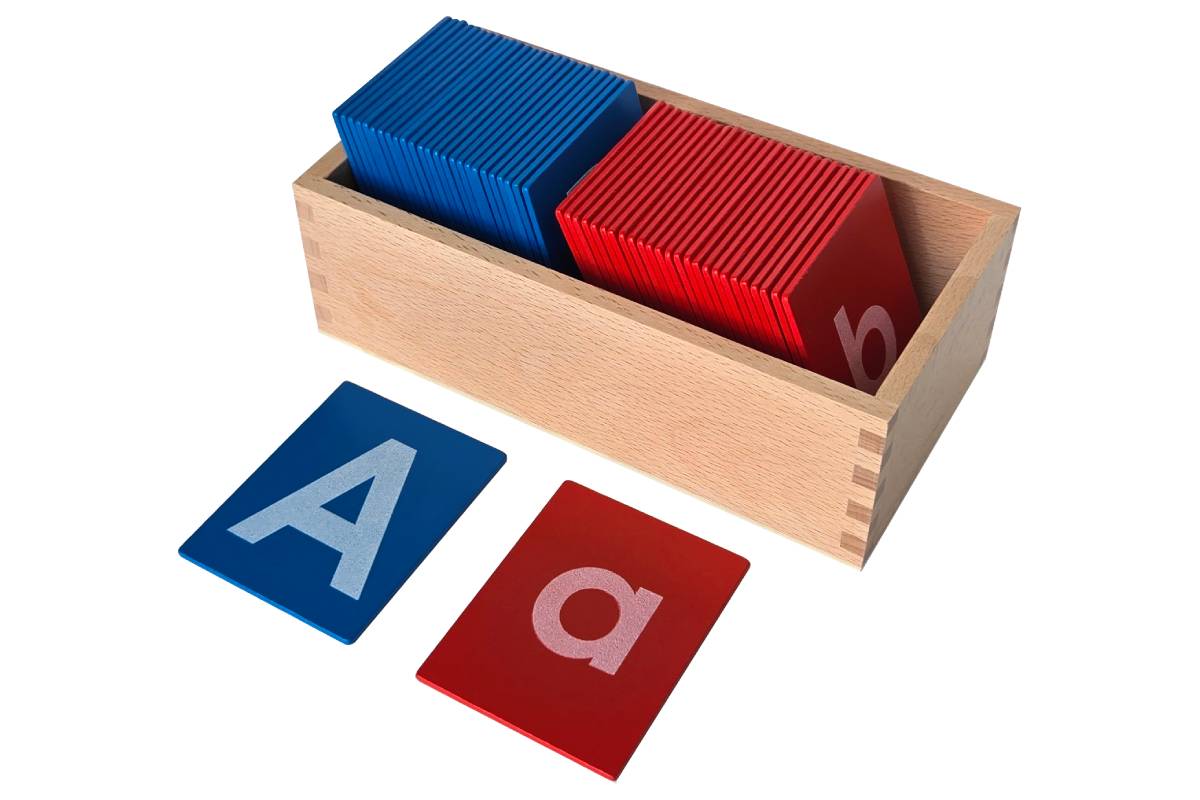 Two-compartment wooden box with blue capital case sandpaper letters in one compartment and red lowercase sandpaper letters in the other.