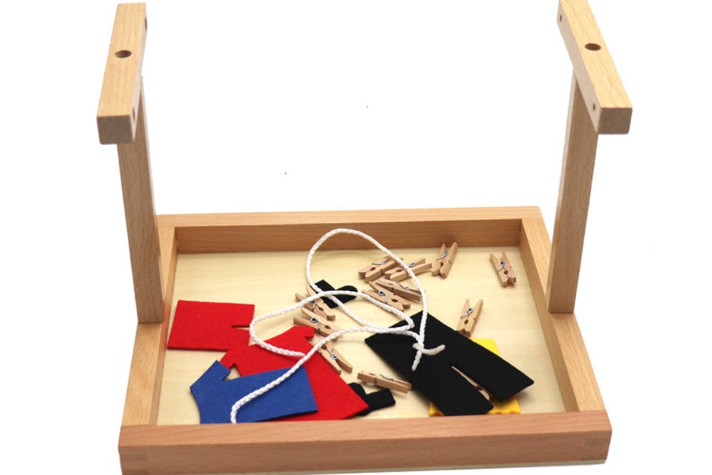 Partially assembled clothesline activity. Vertical and horizontal wooden beams are attached to base in 'T' shape.