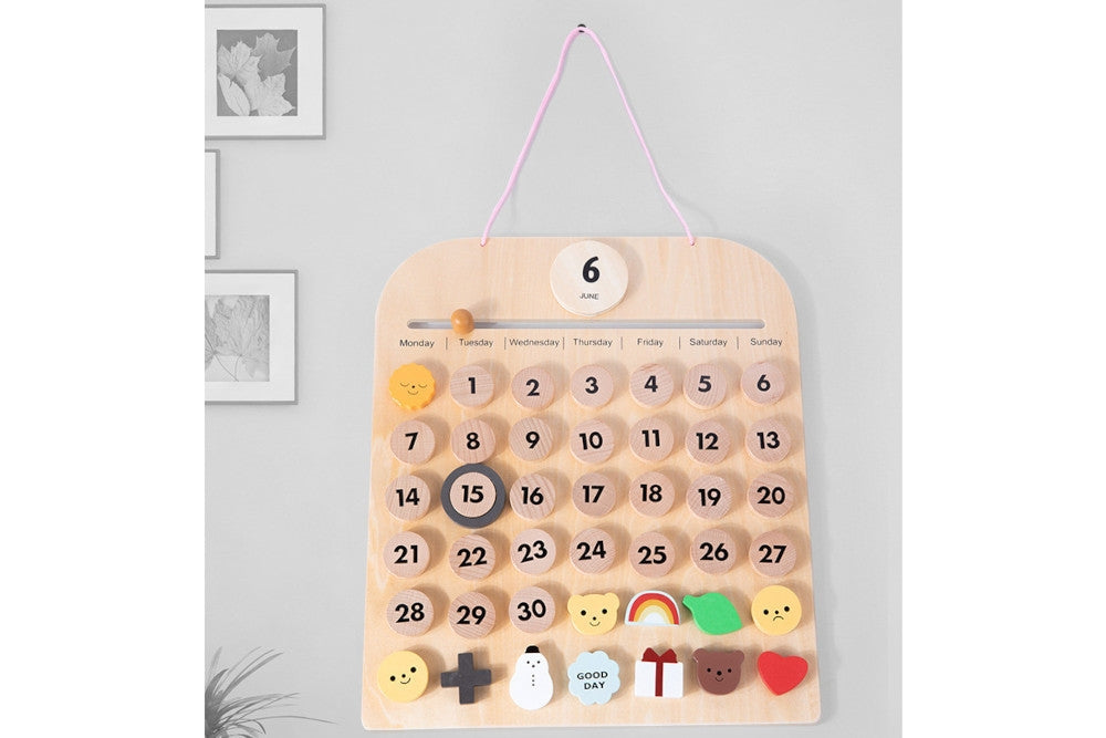 Calendar hanging from the wall through a pink cord.