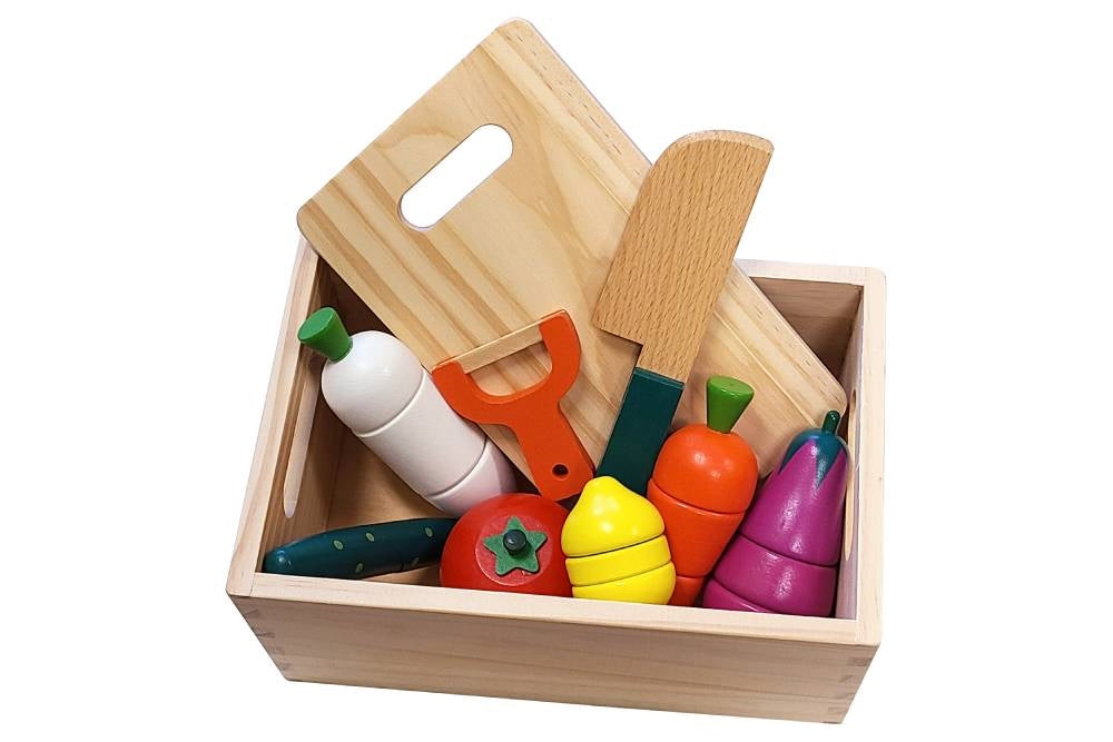 Wooden tray with vegetables, cutting board, knife, and peeler.
