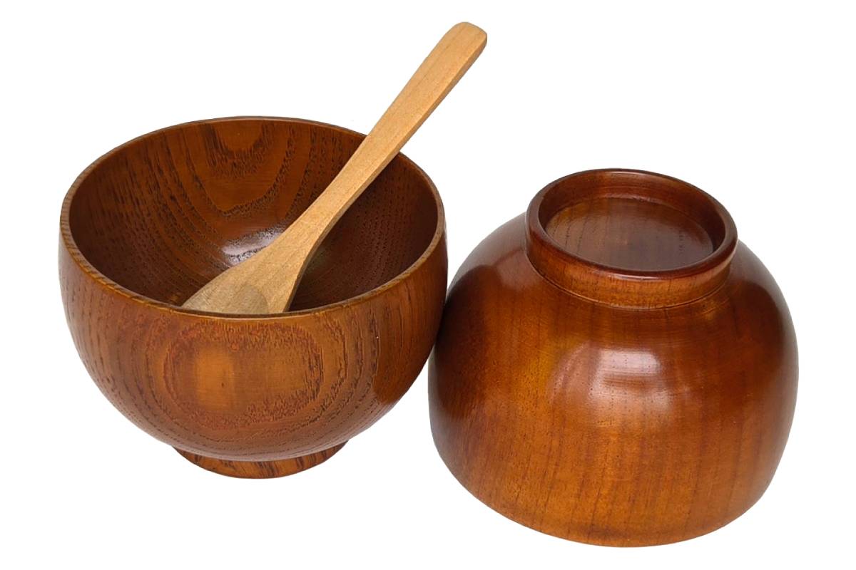 Two dark brown solid wood bowls with a light brown wooden spoon.