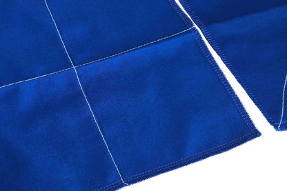Close-up of a piece of blue cloth with a vertical and a horizontal line of stitches in white