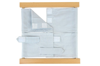 Wooden velcro dressing frame with grey fabric and white velcro.